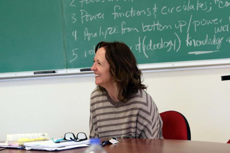 a woman smiling at a table