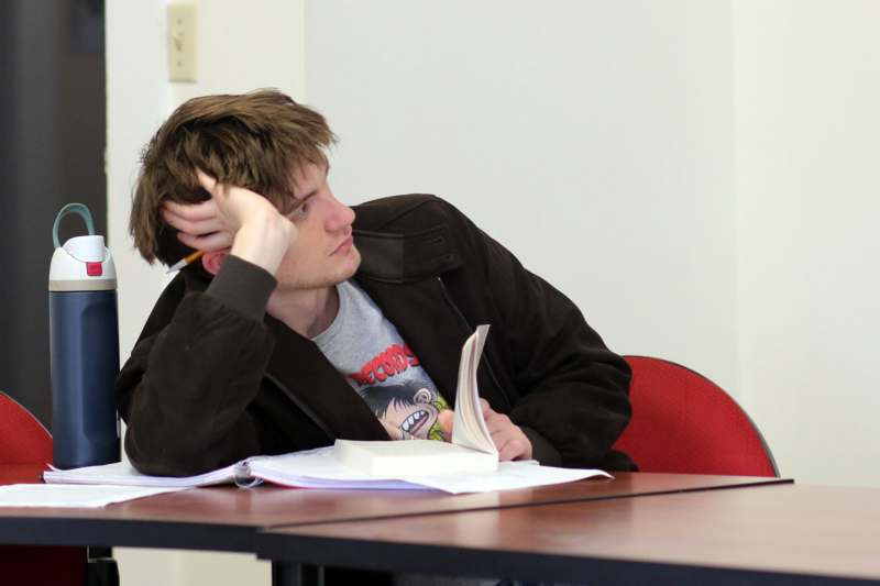 a man sitting at a table with a book