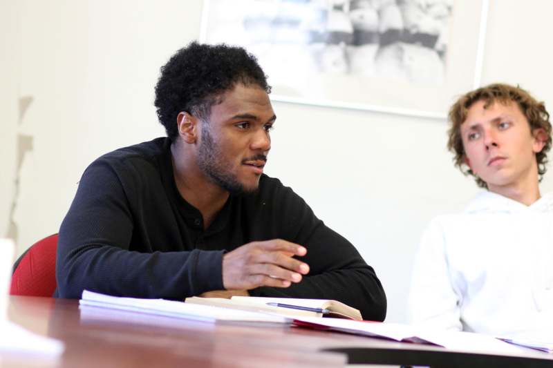 a man sitting at a table with a book and a woman