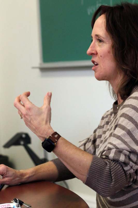 a woman in a striped sweater speaking