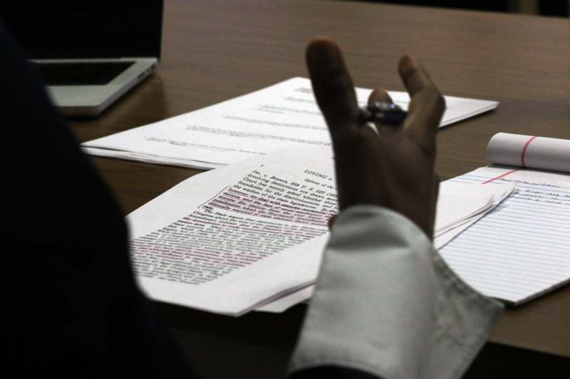 a person holding a pen in front of papers