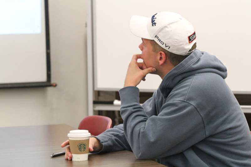 a man in a white cap sitting at a table with a coffee cup