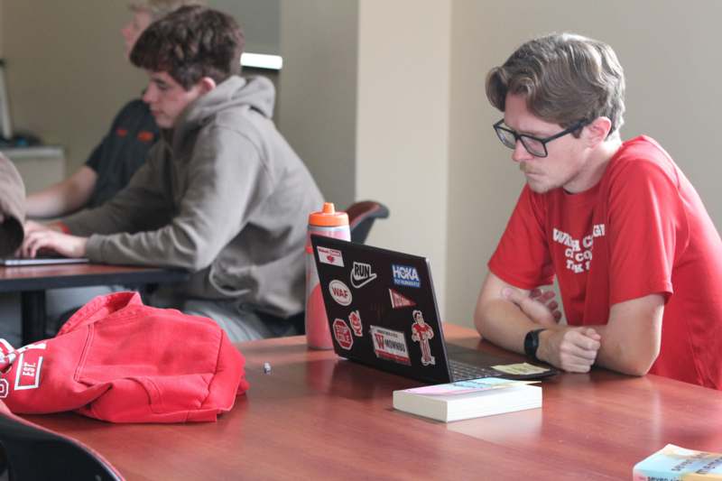 a group of people sitting at a table with a laptop