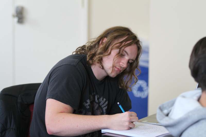 a man writing on a notebook