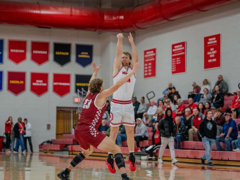 Basketball vs Rose Hulman (11/12/25) - a basketball player in a red uniform jumping to reach the ball