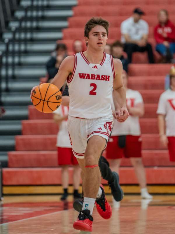 a man in a basketball uniform holding a basketball