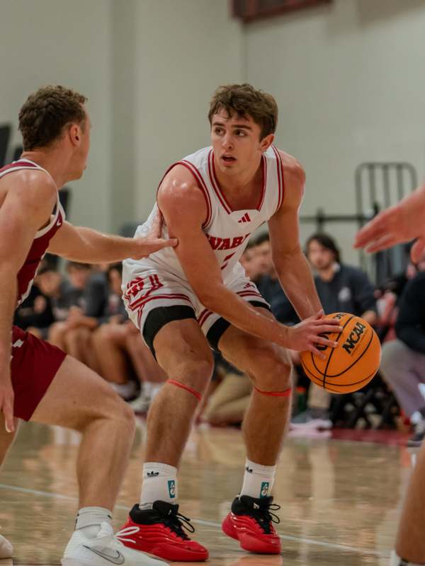 a basketball player in a white uniform dribbling a basketball