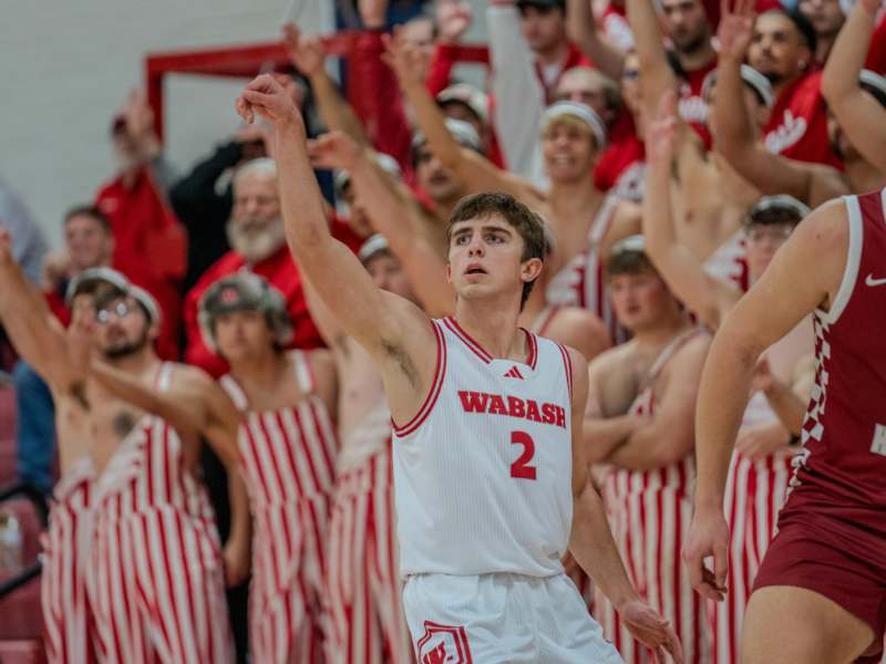 a basketball player in a uniform with his arms up