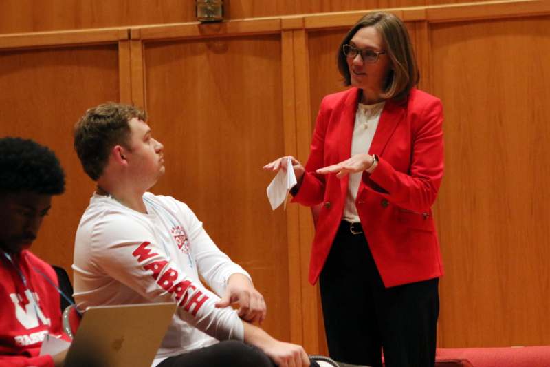 Classroom: RHE 320 with Professor Sara Mehltretter - a woman in a red jacket talking to a man