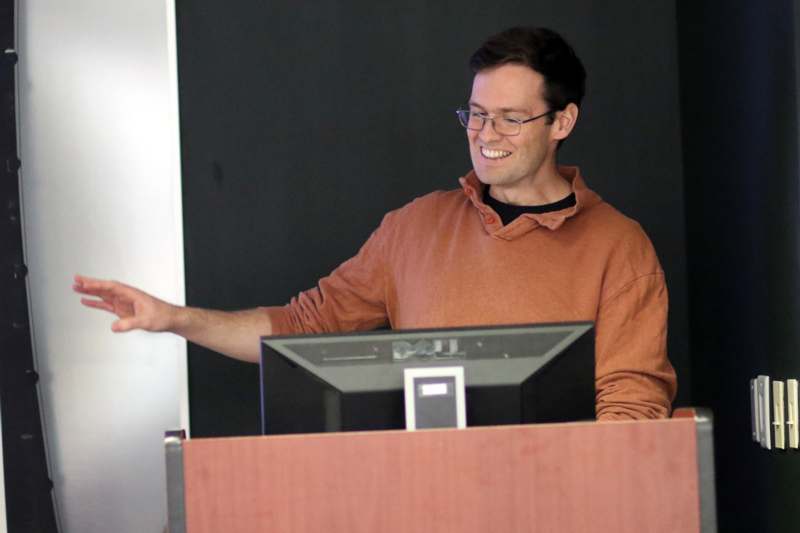a man standing at a podium pointing at something