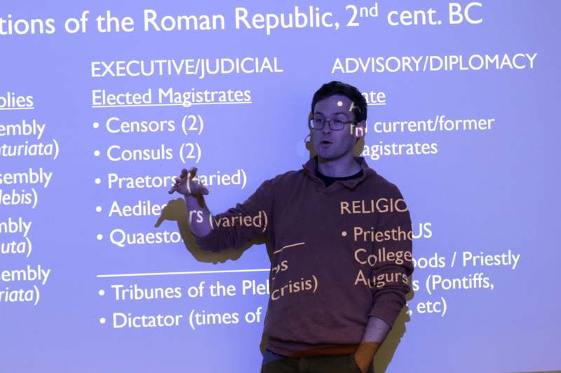 a man standing in front of a large screen