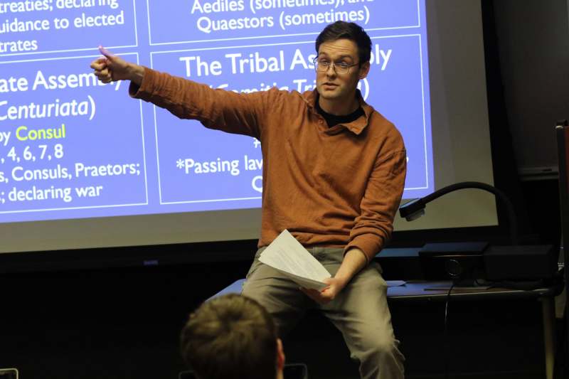 a man sitting on a table pointing at something