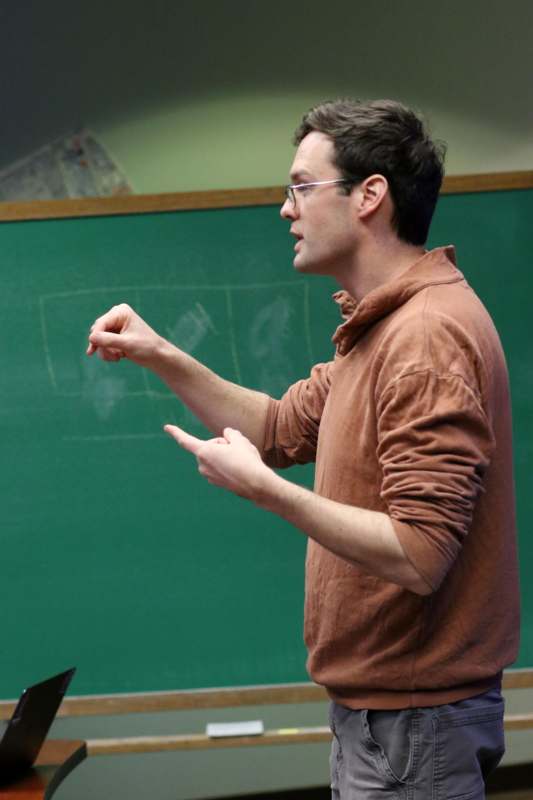 a man standing in front of a chalkboard