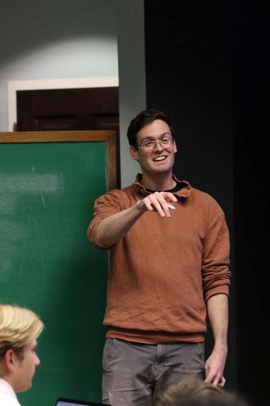a man in glasses and a brown shirt
