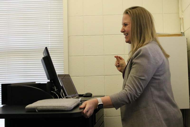 a woman standing in front of a computer