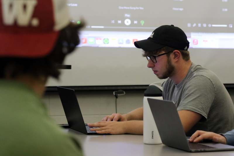 a man sitting at a table with a laptop