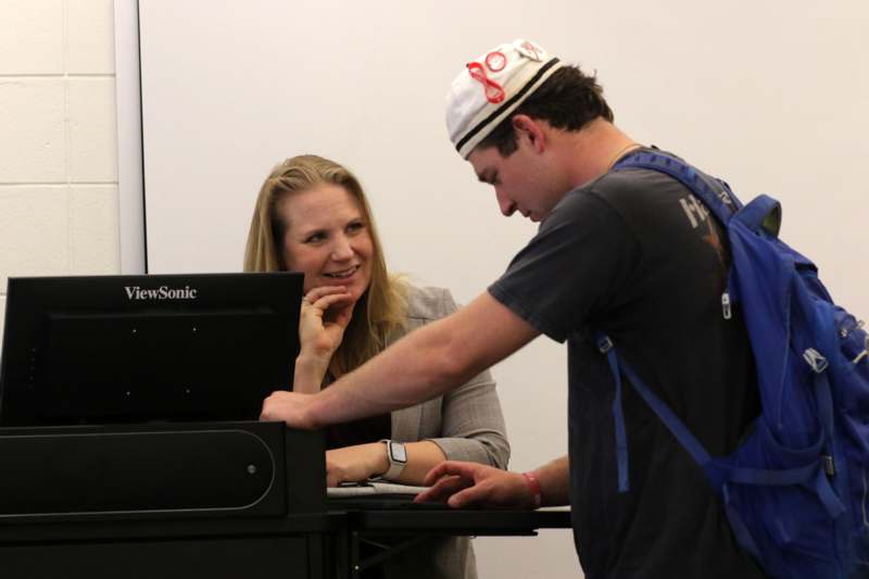 a man and woman looking at a computer