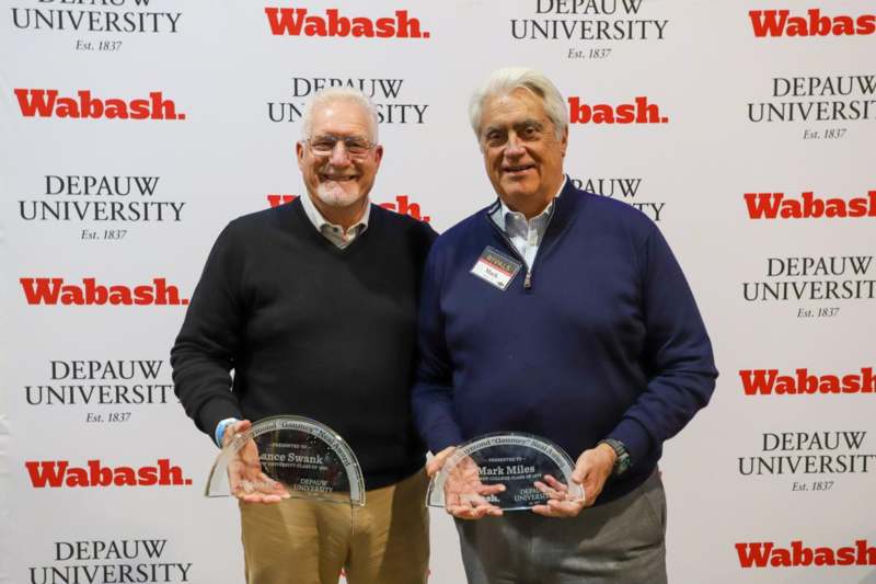 two men holding trophies