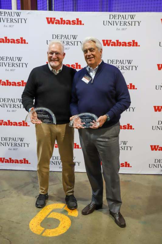two men holding awards