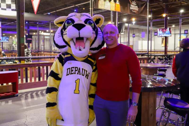 a man standing next to a mascot