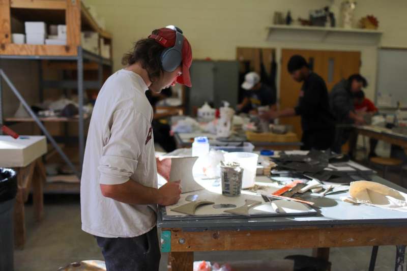 a man wearing headphones working on a piece of art