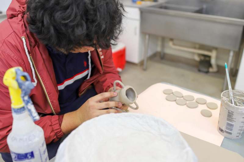 a person working on a clay cup
