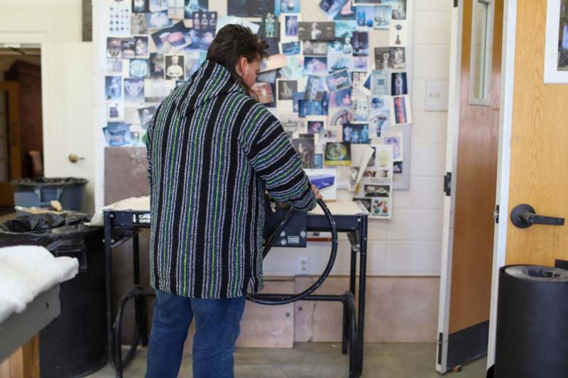 a man in a striped jacket using a machine