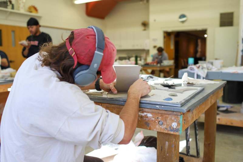 a man wearing headphones and working on a piece of paper