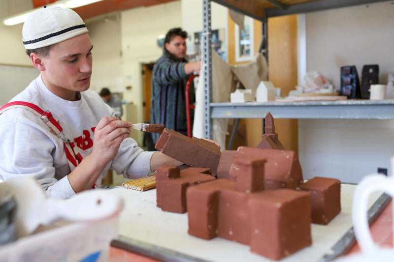 a man painting a model of a building