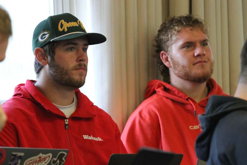 a group of men sitting in front of a window