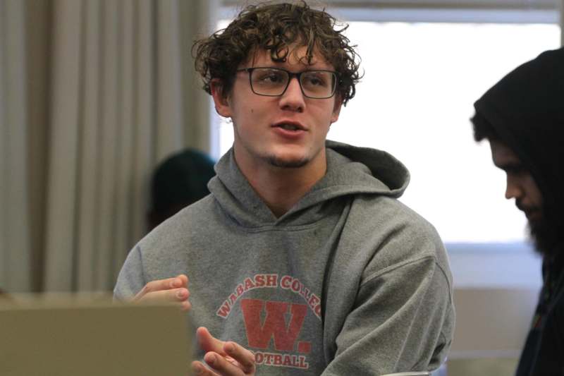 a man wearing glasses and a grey sweatshirt