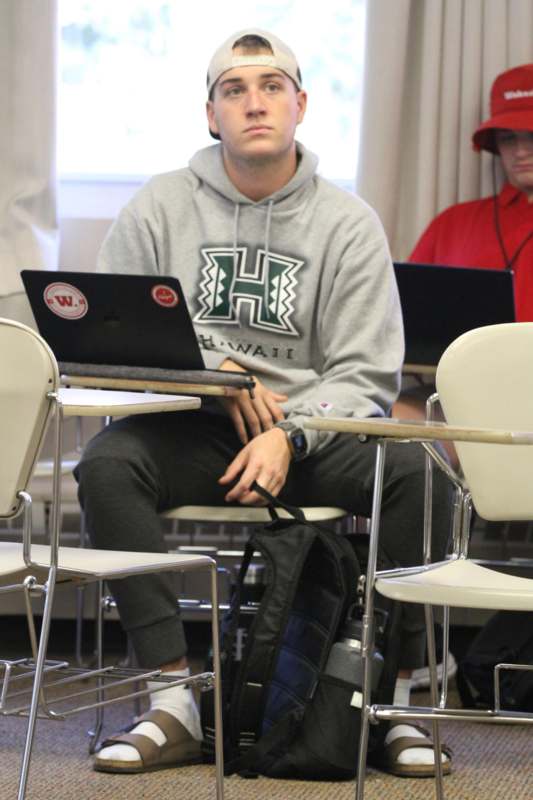 a man sitting at a desk with a laptop
