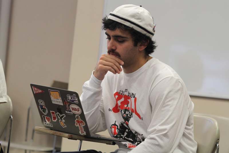 a man sitting at a desk with his hand on his chin