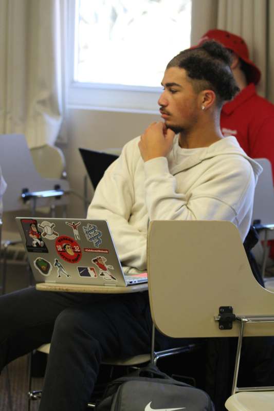 a man sitting in a classroom with a laptop