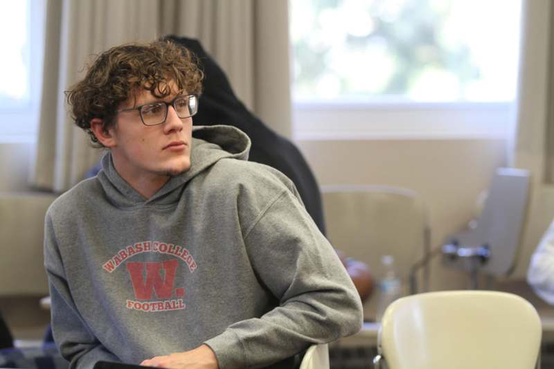a man wearing glasses and a grey sweatshirt