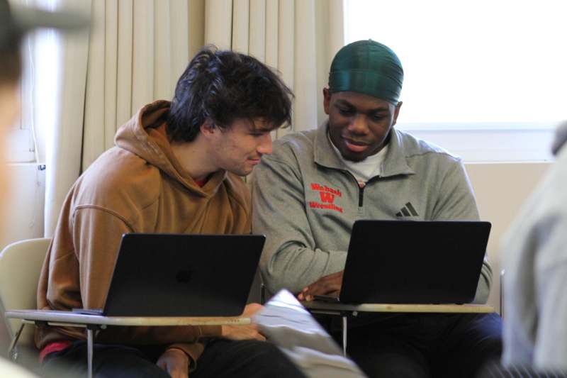 a group of men looking at laptops