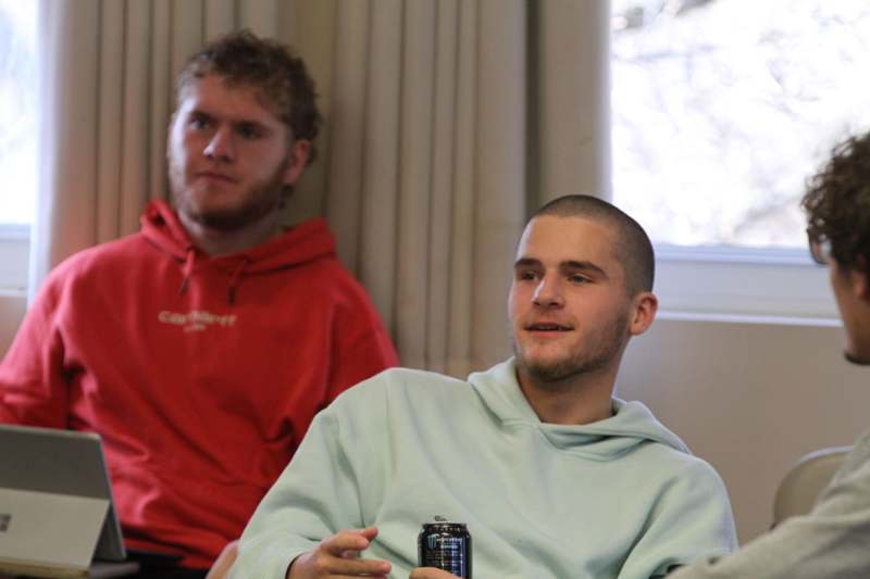 a man sitting in a chair with a can in front of him