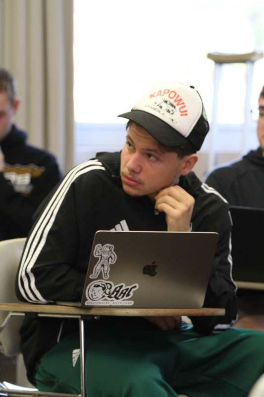 a man sitting at a desk with a laptop