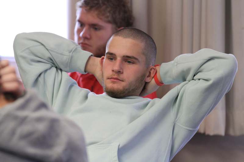 a man with his hands behind his head