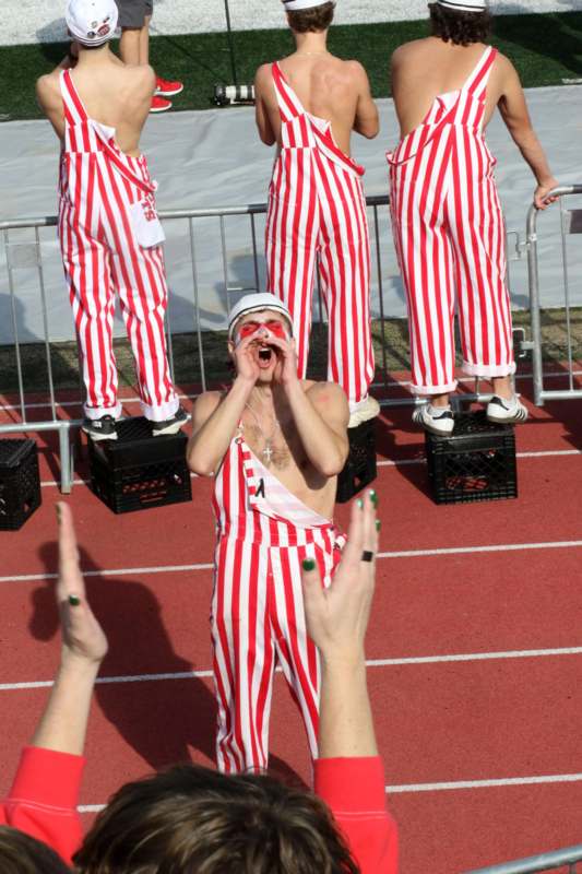 a group of people in striped overalls on a track