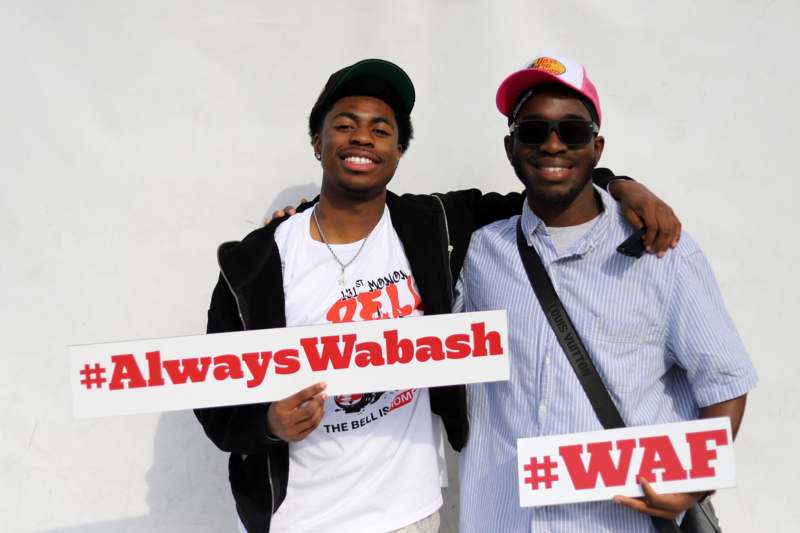 two men holding signs posing for the camera