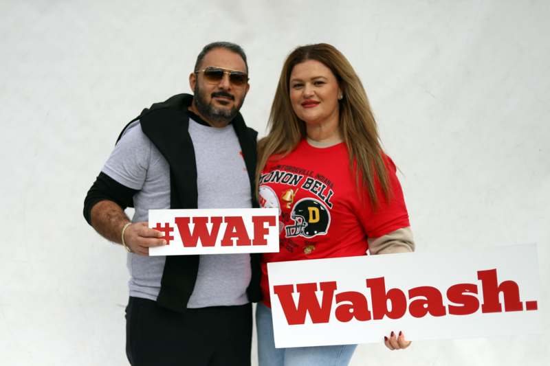 a man and woman holding signs