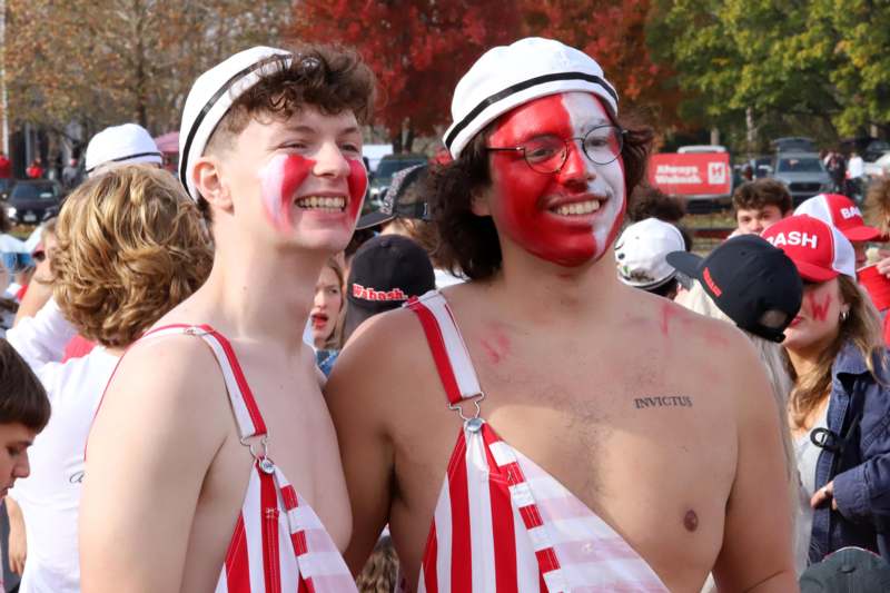 two men wearing red and white striped shirts and white hats