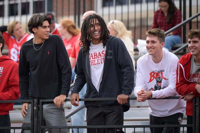 a group of men leaning on a railing