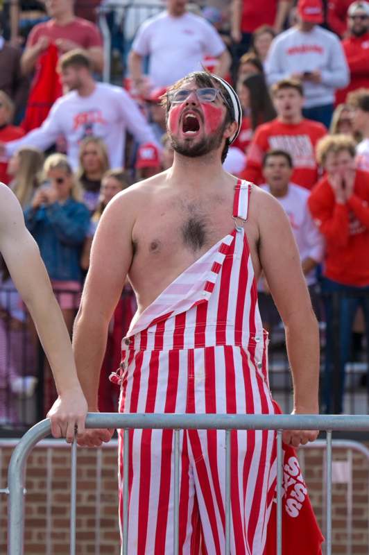 a man wearing red and white striped overalls and a white helmet