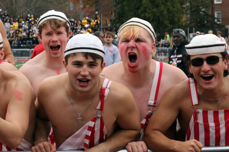 a group of men wearing white hats and suspenders