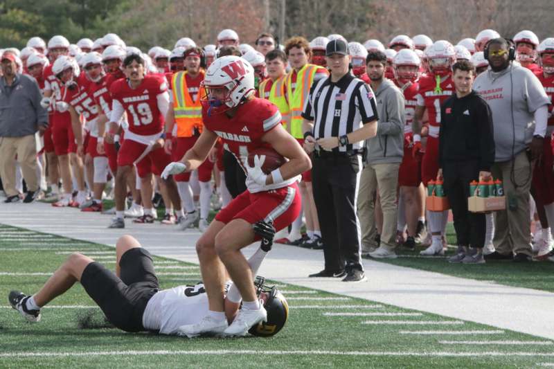 a football player falling on the ground with a group of people watching