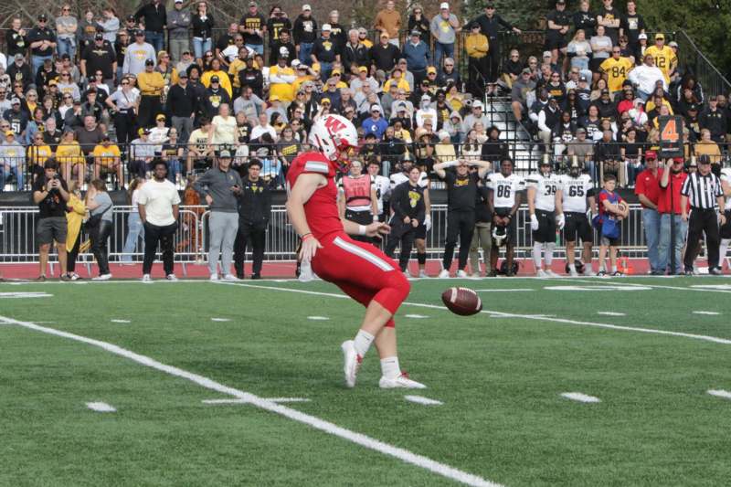 a football player in a red uniform kicking a football