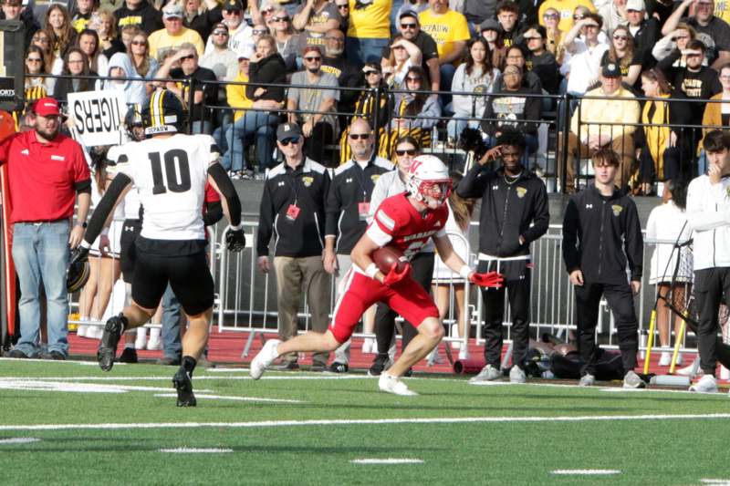 a football player running with a football in the air