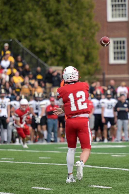 a football player in a red uniform throwing a football